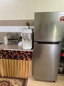 a kitchen with a stainless steel refrigerator next to a counter at AR HOMESTAY KUALA TERENGGANU in Kuala Terengganu