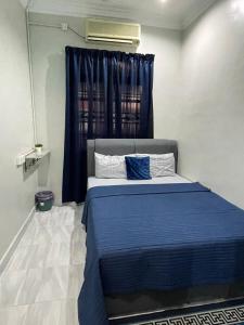 um quarto com uma cama azul e uma janela em AR HOMESTAY KUALA TERENGGANU em Kuala Terengganu