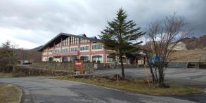 um grande edifício cor-de-rosa ao lado de uma estrada em Yagisawa Corp - Vacation STAY 90026v em Nikko