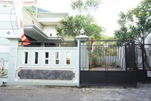 een witte poort voor een huis bij OYO Life 93045 Kost Putra Bu Ketut in Lumajang
