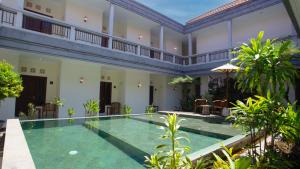 a courtyard with a swimming pool in a house at Teges Inn Kuta in Kuta