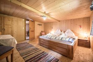 una camera con un grande letto in una stanza con pareti in legno di Alpenzauber / Chalet AlmZeit / Almhütte Zillertal a Schwaz