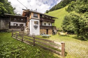 una casa con una recinzione di fronte di Alpenzauber / Chalet AlmZeit / Almhütte Zillertal a Schwaz