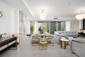 ドバイにあるMaison Privee - Ultra Chic High-Floor Apt with Direct Burj Khalifa & Fountains Viewsのテーブルとソファのあるリビングルーム