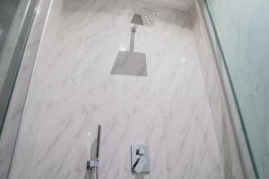 阿布賈的住宿－MercuryIcon luxury Homes，浴室内有标志的白色大理石墙