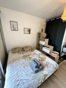 ein Schlafzimmer mit einem Bett mit einer blauen Decke in der Unterkunft The Jungle Studio, loggia & parking dans résidence in Romans-sur-Isère