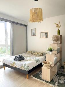 1 dormitorio con cama y ventana grande en The Jungle Studio, loggia & parking dans résidence, en Romans-sur-Isère