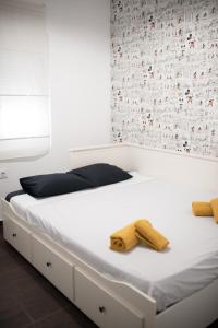 - un lit blanc avec deux blocs en bois dans l'établissement Apartamento de la Cruz, à Mérida