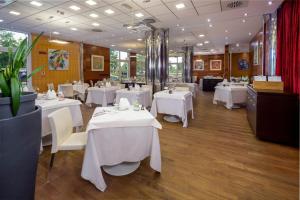 a restaurant with white tables and white chairs at Crowne Plaza Padova, an IHG Hotel in Padova