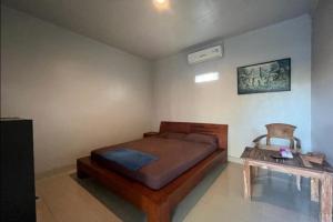 a bedroom with a bed and a table at OYO 93072 Asri Homestay Syariah in Parit