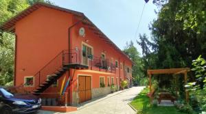 pomarańczowy budynek ze schodami na boku w obiekcie B&B Cascina Grattinera w mieście Sale San Giovanni