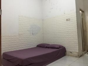 a bedroom with a purple bed in the corner at OYO Life 93009 Griya Nautika Sedati in Sidoarjo