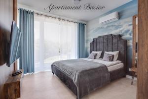 - une chambre avec un lit et une grande fenêtre dans l'établissement Apartament Basior, Laguna Beskidów, à Zarzecze