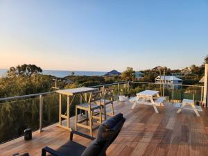 una mujer tendida en una cubierta mirando al océano en Oceanview Manor by "Peppy Beach Retreats" - Two Houses in One with Panoramic Views, en Capel