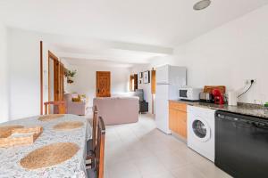 a kitchen and dining room with a table and a washing machine at Casa Luis - APARTAMENTO con JARDÍN PRIVADO en los PIRINEOS in Castiello de Jaca +29 photos