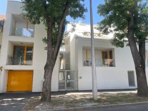 una casa bianca con degli alberi di fronte di Christy’s House a Debrecen