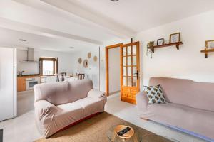 a living room with two couches and a kitchen at Casa Luis - APARTAMENTO con JARDÍN PRIVADO en los PIRINEOS in Castiello de Jaca