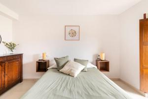 a white bedroom with a large bed with green sheets at Casa Luis - APARTAMENTO con JARDÍN PRIVADO en los PIRINEOS in Castiello de Jaca