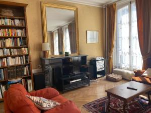 uma sala de estar com lareira e espelho em La maison familiale em Auxerre