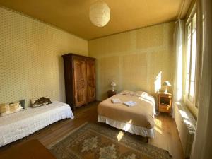 1 dormitorio con cama y ventana en La maison familiale en Auxerre
