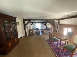 La maison familiale في أوكسير: غرفة معيشة مع طاولة وكراسي خشبية