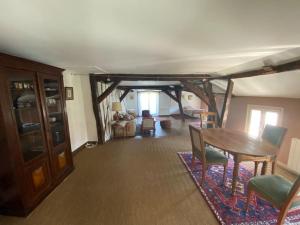 uma sala de estar com uma mesa de madeira e cadeiras em La maison familiale em Auxerre