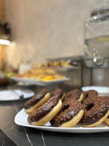 um prato de donuts cobertos de chocolate num balcão em All Seasons Residence em Zlatibor