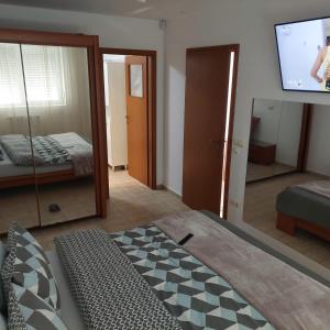 Habitación con cama, TV y espejo. en Apartament Casa Dia, en Sibiu