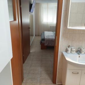 a bathroom with a sink and a room with a bed at Apartament Casa Dia 1 in Sibiu