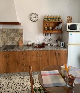 a kitchen with a table and a clock on the wall at Casa Morería in Guadalcanal