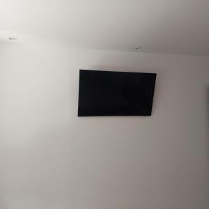 TV de pantalla plana en la parte superior de una pared blanca en Apartament Casa Dia, en Sibiu
