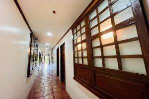 pasillo con puerta de madera y suelo de baldosa en MC's L Transient House en Bantay