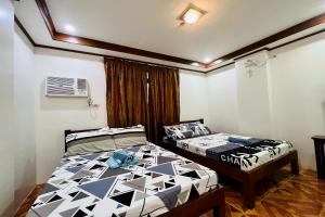 MC's L Transient House في Bantay: غرفة نوم بسريرين في غرفة