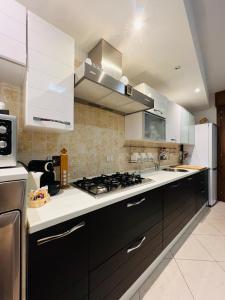 uma cozinha com armários brancos e um forno com placa de fogão em Serendipity em Bentivoglio