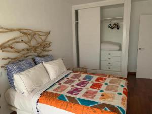 a bedroom with a bed with a quilt on it at Tokyo Rooms "El Cabo" Habitación doble con baño privado in Almería