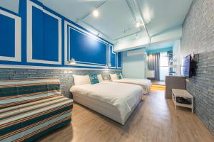 1 dormitorio con 2 camas y pared de ladrillo en 高雄靉嗨文旅, en Kaohsiung