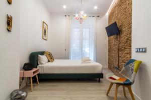 ein Schlafzimmer mit einem Bett und einer Ziegelwand in der Unterkunft 2 habitaciones 2 baños- Moderno y Acogedor - Imperial in Madrid