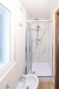 La salle de bains blanche est pourvue d'une douche et d'un lavabo. dans l'établissement Home Holiday Rome - 2° Floor, à Rome