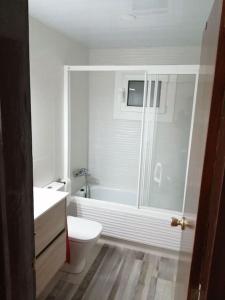 a white bathroom with a toilet and a shower at Pis amb grans vistes a Montserrat in Igualada