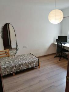 1 dormitorio con 1 cama y escritorio con ordenador portátil en Pis amb grans vistes a Montserrat, en Igualada