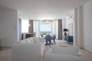 a living room with white couches and a dining room at TD Villa Grecale Modern Luxury Villa with SeaView in Capitolo