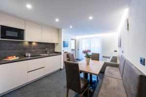 a kitchen and dining room with a table and chairs at Ciasa Mascotte in San Vigilio Di Marebbe