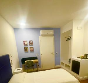 a small room with a bed and a desk and a door at Home 146 in Lamezia Terme