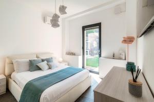 Un dormitorio blanco con una cama grande y una mesa en Como Lake Villa Torno, en Torno