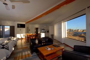 ein Wohnzimmer mit einem Sofa und Stühlen sowie einem großen Fenster in der Unterkunft The Cormorant House in Lüderitz