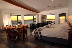 a hotel room with two beds and a table and chairs at The Cormorant House in Lüderitz