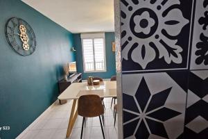a dining room with a white table and blue walls at Appartement calme in Liévin