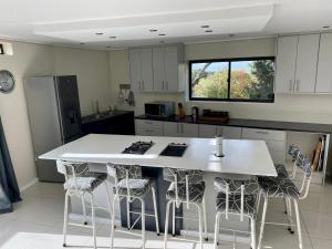 a kitchen with a large white island with bar stools at Rose’s Place in Cape Town