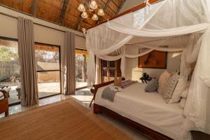 a bedroom with a bed with a canopy at Tomo Safari Lodge in Hoedspruit