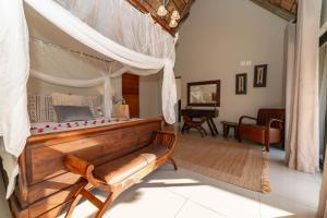 una camera con letto a baldacchino e un soggiorno di Tomo Safari Lodge a Hoedspruit